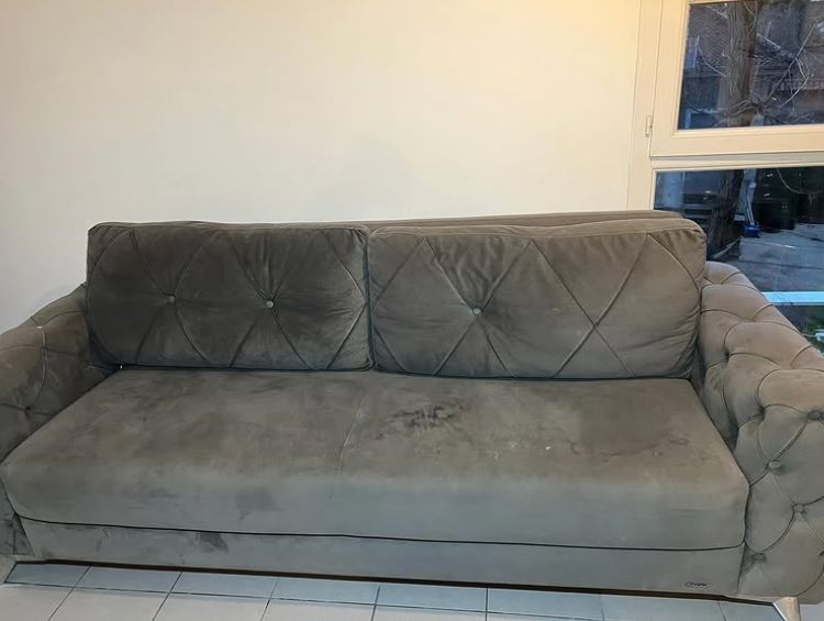 Avant : canapé gris en velours avec des taches sur l'assise