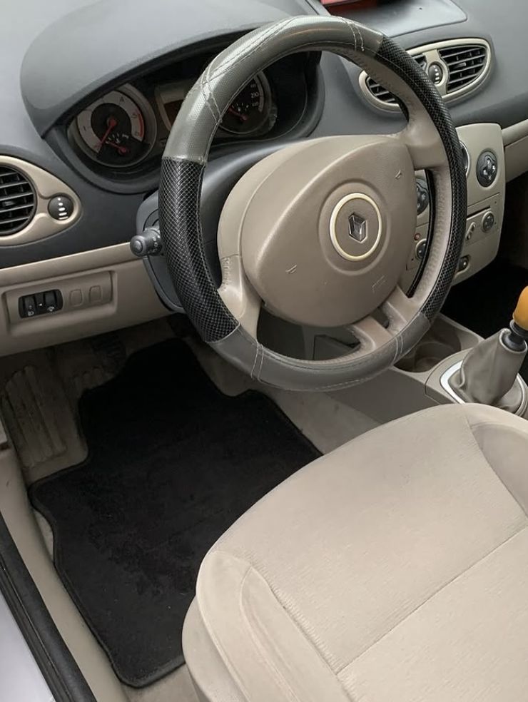 Poste de conduite d'une Renault Clio après nettoyage intérieur : volant, siège et tapis de sol